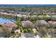 Aerial view showcasing a neighborhood with mature trees, private pools, and nearby lake at 6922 Stanhope Pl, University Park, FL 34201