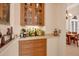 Elegant home bar area featuring a collection of liquor and a dining area at 6922 Stanhope Pl, University Park, FL 34201