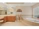 Spacious bathroom with a soaking tub, glass block window, and light tile flooring at 6922 Stanhope Pl, University Park, FL 34201