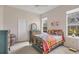 Bright bedroom with colorful quilt, multiple windows and neutral paint at 6922 Stanhope Pl, University Park, FL 34201