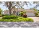 Charming single-story home with a well-manicured lawn, mature trees, and a two-car garage at 6922 Stanhope Pl, University Park, FL 34201