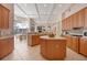 Spacious kitchen with a central island, wood cabinetry, and view of the lanai at 6922 Stanhope Pl, University Park, FL 34201