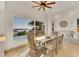 Dining area with a waterfront view, built-in banquette, and travertine flooring at 7064 Hawks Harbor Cir, Bradenton, FL 34207