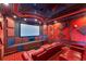 Home theater featuring red leather recliners, a tiered floor, and recessed lighting at 7064 Hawks Harbor Cir, Bradenton, FL 34207