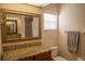 Well-lit bathroom featuring a granite countertop, framed mirror, and modern fixtures at 7113 52Nd E Dr, Bradenton, FL 34203