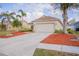Charming single-story home featuring a manicured lawn, palm trees, and a spacious two-car garage at 7113 52Nd E Dr, Bradenton, FL 34203