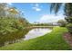 Picturesque waterfront view showcasing a serene lake surrounded by lush greenery and mature trees at 7339 Birds Eye Ter, Bradenton, FL 34203