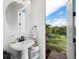 Powder room featuring white pedestal sink and view of a lake through the open doorway at 8284 Barton Farms Blvd, Sarasota, FL 34240