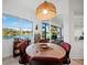 Waterfront breakfast nook with views of the lake, modern lighting, and a dining table with seating at 8284 Barton Farms Blvd, Sarasota, FL 34240