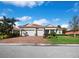 Beautiful single-story home featuring a brick driveway, manicured lawn, and a three-car garage at 8284 Barton Farms Blvd, Sarasota, FL 34240