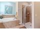 Bright bathroom features a soaking tub, separate glass-enclosed shower, and neutral tile at 9043 39Th Street E Cir, Parrish, FL 34219