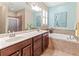Elegant bathroom with double sinks, large mirror, and separate tub and shower at 9043 39Th Street E Cir, Parrish, FL 34219