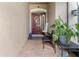 Charming front entrance with brick flooring, inviting door with wreath, and decorative potted plants at 9043 39Th Street E Cir, Parrish, FL 34219