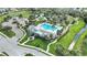 A vibrant aerial view showcases a community center, swimming pool, playground, and surrounding green spaces at 11231 Woodlake Way, Parrish, FL 34219