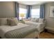 Cozy bedroom with two beds, soft lighting, and soothing blue curtains at 1129 Montrose Pl, Dunedin, FL 34698