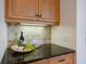 Wet bar area with dark granite counters and wooden cabinetry at 11728 Strandhill Ct, Lakewood Ranch, FL 34202