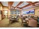 The dining area features a warm, inviting atmosphere with ample seating, TVs and wood trim at 11728 Strandhill Ct, Lakewood Ranch, FL 34202