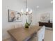Elegant dining room features a modern chandelier, stylish artwork, and comfortable seating for sophisticated dinners at 11728 Strandhill Ct, Lakewood Ranch, FL 34202