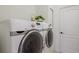 Laundry room features side-by-side Samsung washer and dryer and a decorative plant sitting on top at 11728 Strandhill Ct, Lakewood Ranch, FL 34202