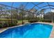 Screened-in pool features serene views of mature trees and a meticulously manicured lawn at 11728 Strandhill Ct, Lakewood Ranch, FL 34202