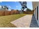 Well-maintained backyard featuring a wooden fence, large shade tree, and paved patio, perfect for outdoor entertaining at 1471 Palmwood Dr, Sarasota, FL 34232