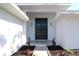 Eye-level of modern front door with sidelights, planters, and symmetrical wall sconces at 1471 Palmwood Dr, Sarasota, FL 34232