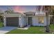 Charming single-story home with a well-manicured lawn, a gray garage door, and a modern front door at 1471 Palmwood Dr, Sarasota, FL 34232