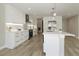 Modern white kitchen with stainless steel appliances, pendant lighting, and hardwood floors at 1471 Palmwood Dr, Sarasota, FL 34232