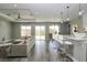 Open-concept kitchen, dining and living area with hardwood floors and natural light at 1471 Palmwood Dr, Sarasota, FL 34232