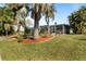 Backyard features a lush lawn, beautiful landscaping, and a screened-in lanai for outdoor living at 198 Salem Nw Ave, Port Charlotte, FL 33952