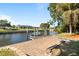 Waterfront backyard features a dock, grassy area, and lush landscaping, perfect for outdoor enjoyment at 198 Salem Nw Ave, Port Charlotte, FL 33952