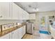 Laundry room features white cabinets, countertop space, a washing machine, and outdoor access at 198 Salem Nw Ave, Port Charlotte, FL 33952