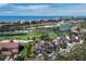 Magnificent aerial view of the tan-roofed house with a golf course, lake and ocean with city views at 2065 Harbour Links Dr # 5, Longboat Key, FL 34228