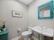 Charming powder room features a decorative mirror and a pedestal sink at 2065 Harbour Links Dr # 5, Longboat Key, FL 34228