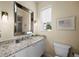 Elegant bathroom featuring marble countertops, a large mirror, and natural light at 2065 Harbour Links Dr # 5, Longboat Key, FL 34228