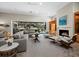 Beautifully furnished living room showcasing fireplace, built-in shelving, and expansive view of the pool and lanai at 2065 Harbour Links Dr # 5, Longboat Key, FL 34228