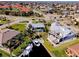 An aerial view displays a home with a pool, lush landscaping, canal access, and proximity to nearby roads and water at 2501 W Marion Ave, Punta Gorda, FL 33950