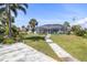 Backyard features a screened enclosure, well maintained lawn, patio and tropical landscaping at 2501 W Marion Ave, Punta Gorda, FL 33950