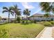 Well manicured lawn and landscaping in backyard with canal views; boat dock, lift, and neighboring homes visible at 2501 W Marion Ave, Punta Gorda, FL 33950
