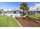 Backyard features lush lawn and landscaping, as well as a partially visible screened in patio at 2501 W Marion Ave, Punta Gorda, FL 33950