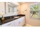 Bathroom featuring granite countertop, white cabinetry, decorative mirror, and natural light at 2501 W Marion Ave, Punta Gorda, FL 33950