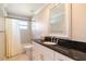Well-lit bathroom featuring granite countertop, white cabinetry, tile flooring, and shower at 2501 W Marion Ave, Punta Gorda, FL 33950