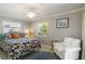 Comfortable bedroom featuring a tropical-themed bed and a cozy armchair at 2501 W Marion Ave, Punta Gorda, FL 33950