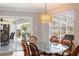 Cozy dining room with a glass table, rattan chairs, and a stylish woven pendant light at 2501 W Marion Ave, Punta Gorda, FL 33950