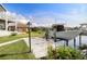Back yard featuring a boat dock and lift on the canal, a lush lawn, and views of neighboring homes at 2501 W Marion Ave, Punta Gorda, FL 33950