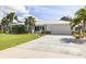 Inviting curb appeal with a spacious driveway, lush lawn and a white metal roof at 2501 W Marion Ave, Punta Gorda, FL 33950