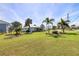 Spacious front yard featuring well-maintained landscaping, lush lawn, and palm trees at 2501 W Marion Ave, Punta Gorda, FL 33950