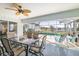 Screened in patio area featuring a ceiling fan, outdoor table and chairs, and a view of the pool and canal at 2501 W Marion Ave, Punta Gorda, FL 33950