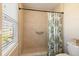 Shower stall features tile surround, a grab bar, and a window for natural light at 2501 W Marion Ave, Punta Gorda, FL 33950