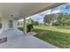 Covered back porch looking out to large, grassy backyard with trees and pool at 26052 Salonika Ln, Punta Gorda, FL 33983